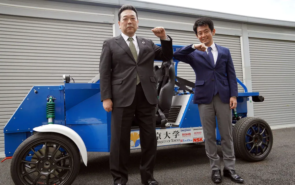 大越社長と藤本教授が電気自動車の前でポーズを取っている様子